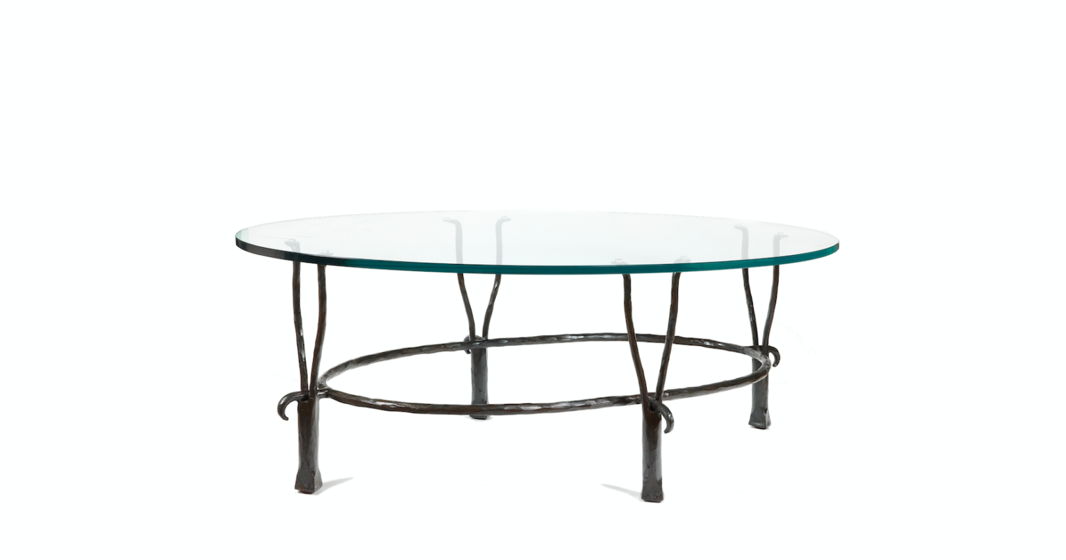 Garouste Bonetti, table basse minimaliste ovale pieds en fer forgé noir qui se séparent en haut en deux petites fourches, situées sous le plateau de verre