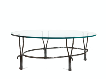 Garouste Bonetti, table basse minimaliste ovale pieds en fer forgé noir qui se séparent en haut en deux petites fourches, situées sous le plateau de verre