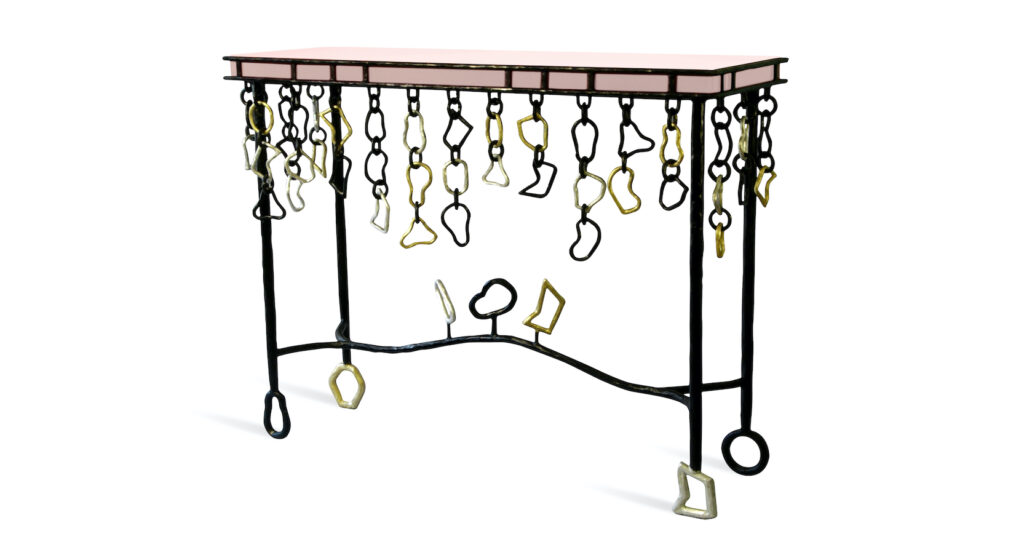 console Elizabeth Garouste en fer forgé noir avec des chaines en fer forgé noires et or qui pendent et un plateau en bois laqué rose