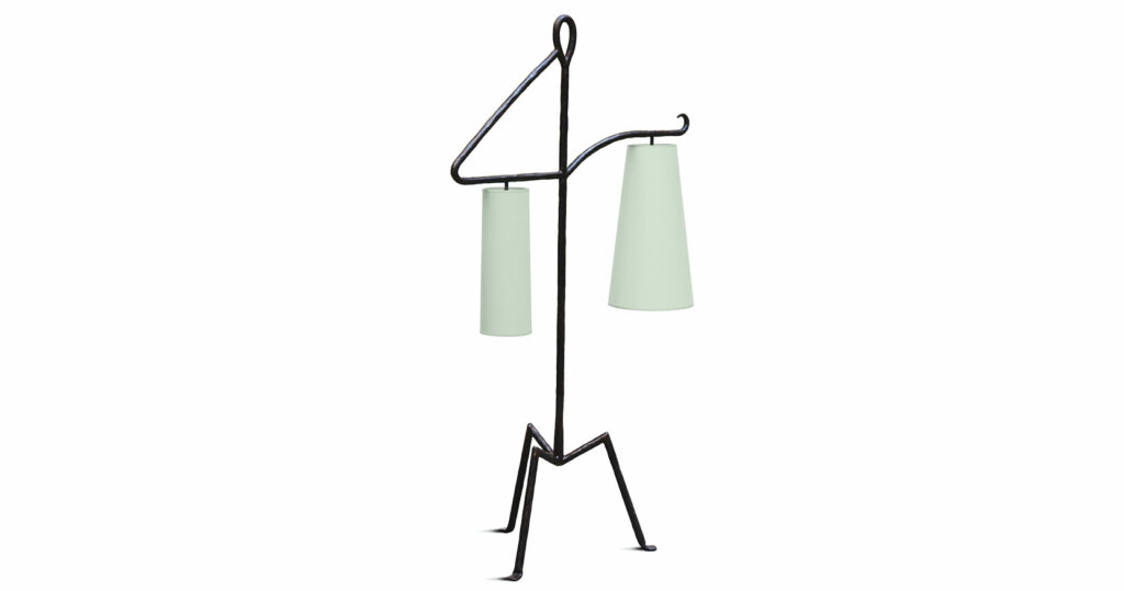 Elizabeth Garouste, floor lamp sculpture in black wrought iron, with 3 feet at acute angles, a vertical rod, and two long horizontal arms with two large pale green lampshades of different sizes and shapes