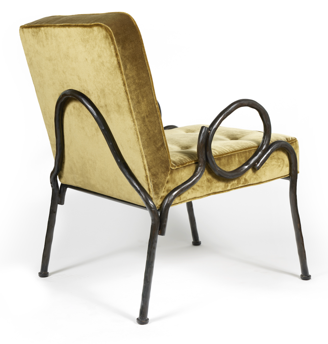 Rear view of the Ravello armchair, designed by Eric Schmitt, with black wrought iron armrests and green velvet