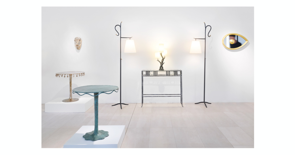 Septembre 2026, Vue de l'exposition "Garouste? ou Bonetti? "chez Sothebys : console en fer forgé brun et guéridons ronds en bronze or et en bronze brun, lampadaires en fer forgé brun, miroir en forme d'oeil en bois doré Créations Garouste et Bonetti, Elizabeth Garouste et Mattia Bonetti