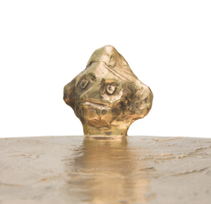 Close-up of the "Golden Him" ​​side table by Elizabeth Garouste, made of gilt bronze and featuring a man's face; a limited edition piece.